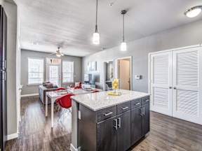 a kitchen with an island and a dining room in the background at Republic at Alamo Heights, San Antonio