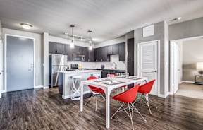 a dining area with a table and chairs and a kitchen in the background at Republic at Alamo Heights, Texas, 78209