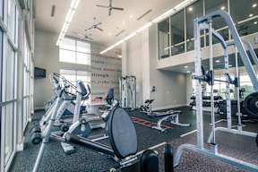 a gym with weights and other exercise equipment at Republic at Alamo Heights, San Antonio, TX