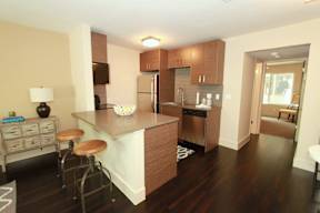 A kitchen with a white counter top and wooden cabinets.