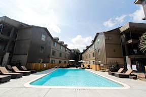 A swimming pool in front of apartment buildings.
