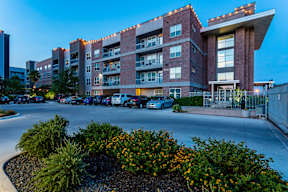 a large brick building with a parking lot in front of it at Republic at Alamo Heights, San Antonio, TX