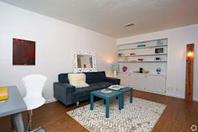 Living room with builtin shelving and modern furniture at Creekline Apartments, Austin, TX
