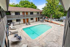 A swimming pool in a courtyard surrounded by trees.