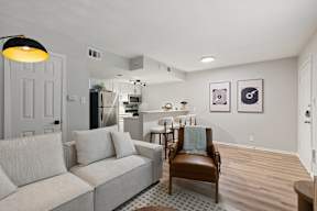 A living room with a grey couch and a brown leather chair.