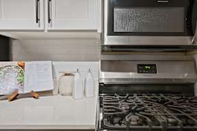 A kitchen with a stove and a microwave oven.