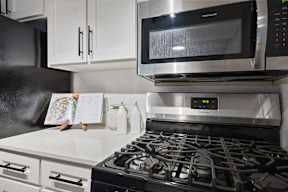 A modern kitchen with a stove, microwave, and oven.
