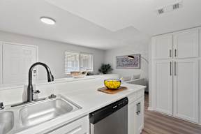 A modern kitchen with white cabinets and stainless steel appliances.