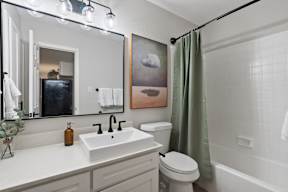 A bathroom with a white sink, toilet, and bathtub.