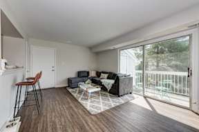 A living room with a grey couch and a wooden floor.