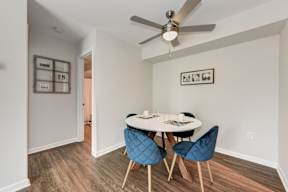 A dining room with a white table and blue chairs.