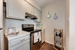 A kitchen with a white oven and a white fridge.