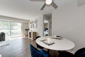 A dining room with a white table and blue chairs.