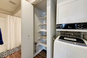 A white washing machine is in a small laundry room.