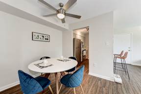 A dining room with a white table and blue chairs.