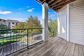 A balcony with a black railing and a white door.