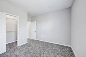 A room with white walls and a grey carpet.