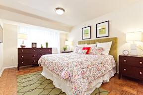 A bedroom with a floral bedspread and a green headboard.