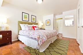 A bedroom with a floral bedspread and a green headboard.