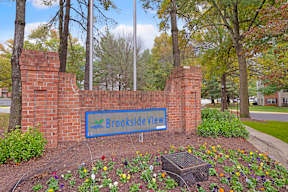 A sign that says Brookside View in front of a brick wall.