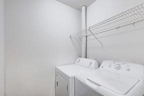 A white washing machine and dryer in a laundry room.