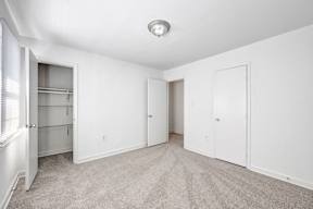 A white room with a carpeted floor and three doors.