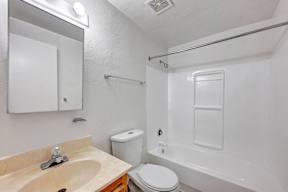 A white bathroom with a sink, toilet, and bathtub.