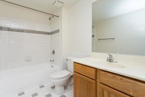 A white toilet sits next to a white sink in a bathroom.