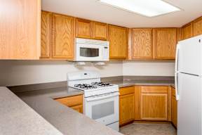 A kitchen with wooden cabinets and white appliances.