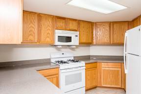 A kitchen with wooden cabinets and white appliances.