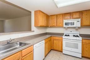 A kitchen with a white stove and a white dishwasher.