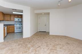 A room with a carpeted floor and a door leading to another room.