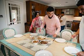 A group of people are gathered around a table with plates of food.