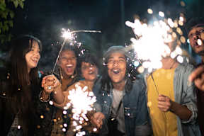 A group of people are holding sparklers and enjoying a night out.