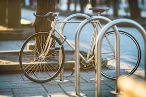 A bicycle is locked to a metal bike rack.