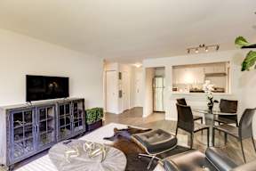 A modern living room with a glass table and chairs.