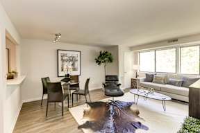 A living room with a cowhide rug and a white couch.