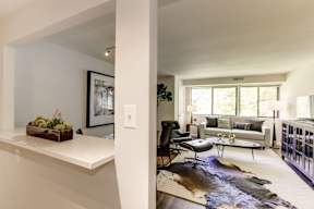 A living room with a white couch and a black chair.