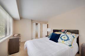 A bedroom with a large bed and a nightstand.