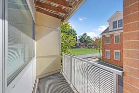 A balcony with a metal railing and a glass door.