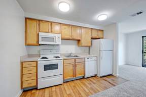 A kitchen with wooden cabinets and white appliances.