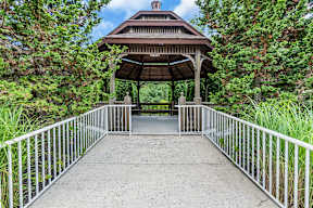 The Monmouth Manasquan, NJ - A gazebo is surrounded by trees and a metal railing.
