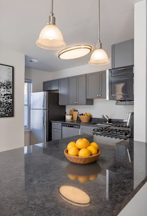 A kitchen with a bowl of lemons on the counter.
