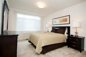 A bedroom with a bed, nightstand, and lamp at Dominion Towers Apartments, Arlington, 22204
