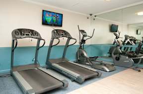 A gym with treadmills and exercise bikes at Dominion Towers Apartments, Arlington