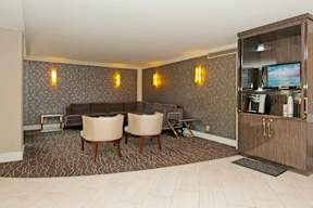 A living room with a grey sofa and a television at Dominion Towers Apartments, Arlington, VA