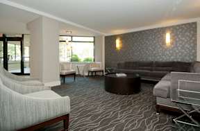 A living room with a grey couch and a black coffee table at Dominion Towers Apartments, Arlington, 22204