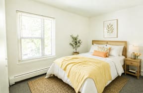 A bedroom with a bed covered in a yellow blanket.