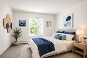A bedroom with a bed, nightstand, and two framed pictures on the wall.