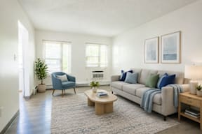 A living room with a blue chair and a grey couch.
